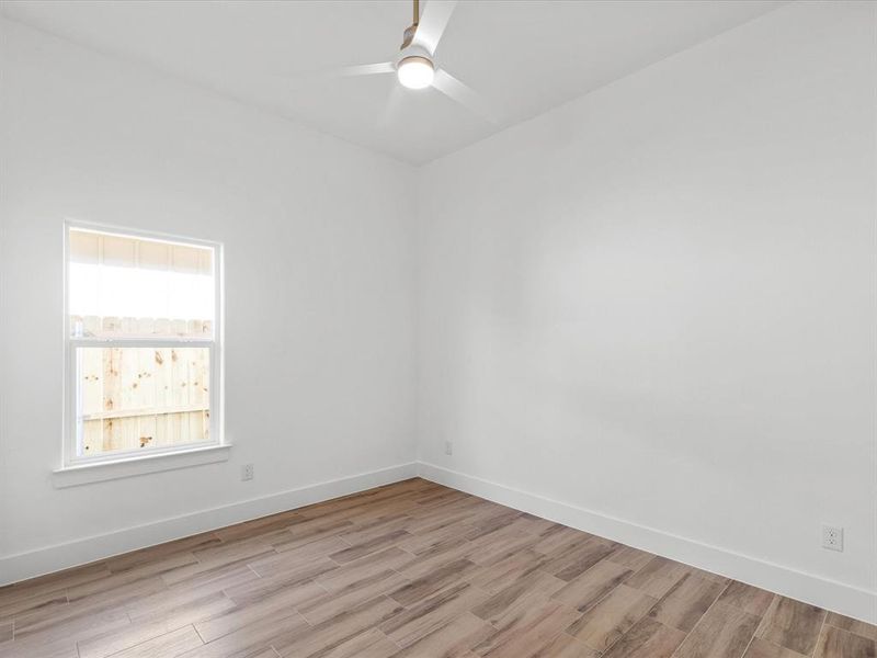 Empty room featuring light wood finished floors and ceiling fan