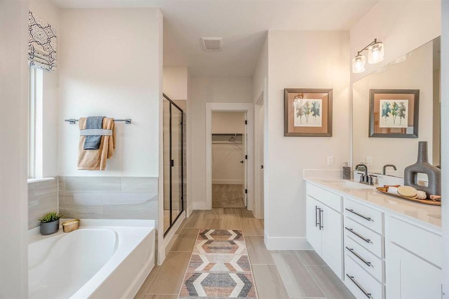 Bathroom with shower with separate bathtub, vanity, and tile patterned floors