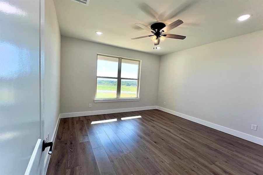 Spare room featuring dark flooring, a ceiling fan, and recessed lighting