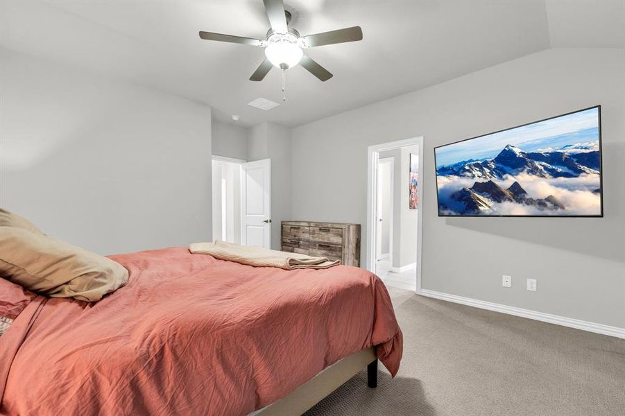 Bedroom featuring ceiling fan, light colored carpet, and lofted ceiling