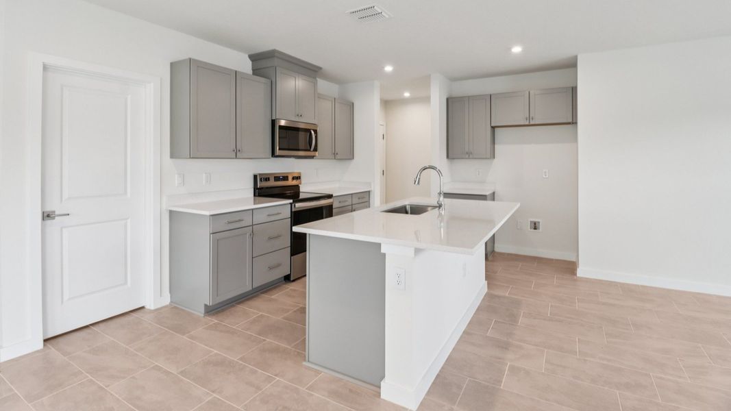 Kitchen and Living Room in the Monterey End Townhome by DRB Homes - Cyrene at Harmony in St Cloud FL