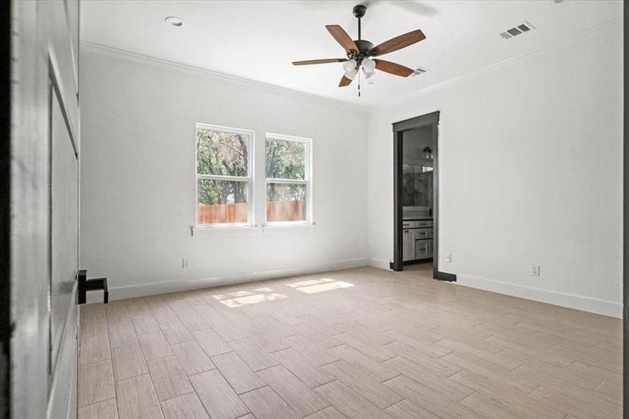 Unfurnished bedroom featuring ornamental molding, wood tiled floors, connected bathroom, and a ceiling fan