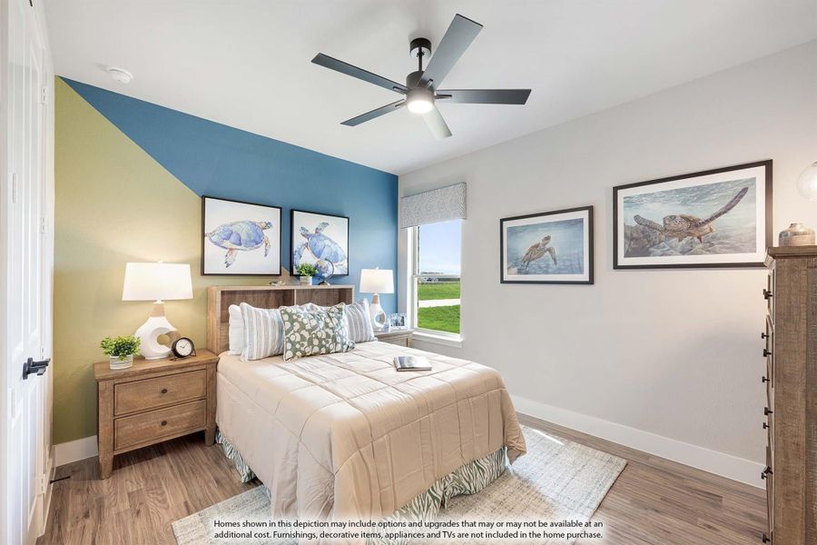 Bedroom with wood floors, ceiling fan, accent wall, and sea turtle wall art above a queen bed