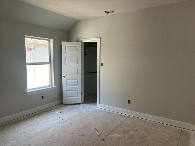 Spare room with baseboards and lofted ceiling