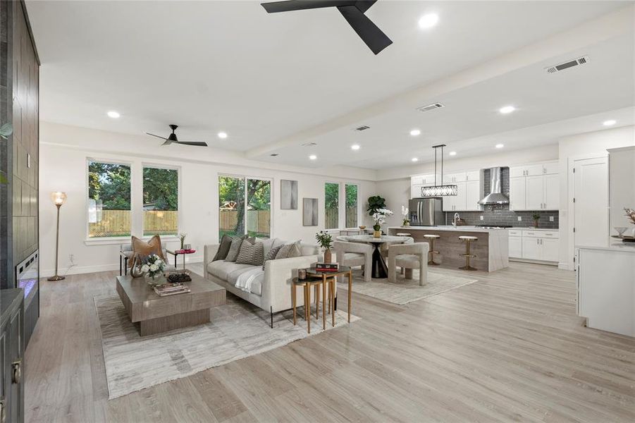 Living area with a ceiling fan, light wood-type flooring, and recessed lighting Living area with a ceiling fan, light wood-type flooring, and recessed lighting