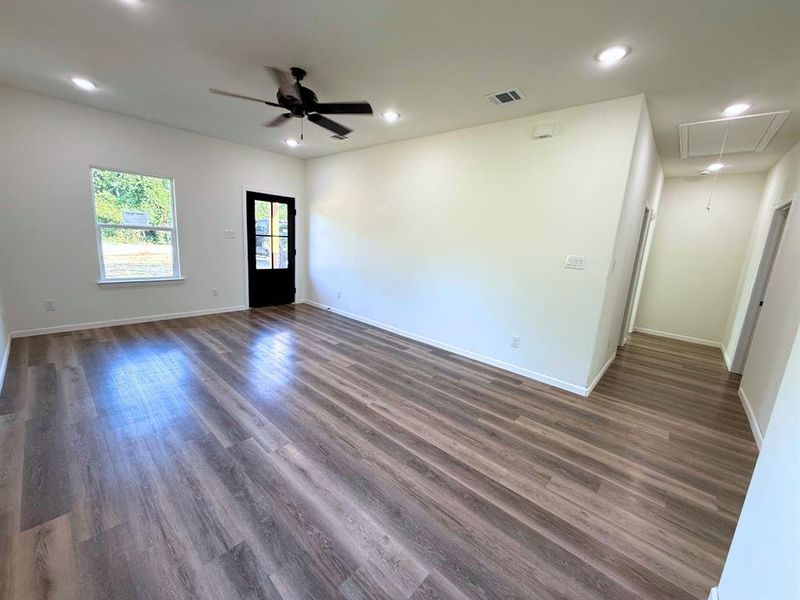 Empty room with attic access, dark wood-style floors, recessed lighting, and ceiling fan