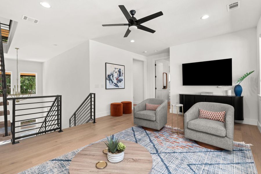 Bright and modern living area with hardwood floors and features ample natural light from the many windows.