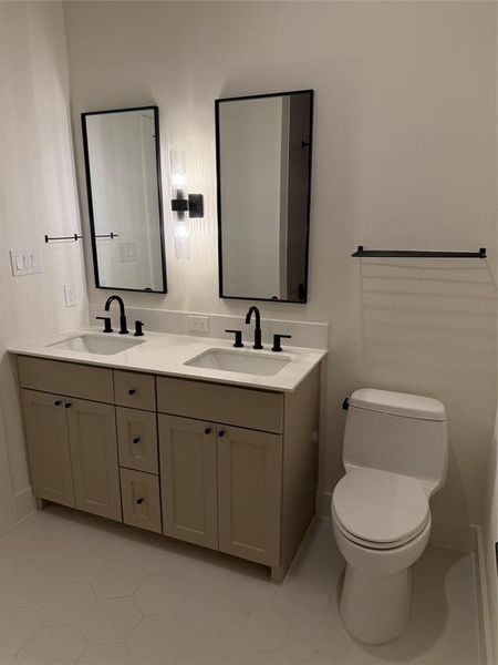 Bathroom featuring toilet, vanity, and tile patterned flooring