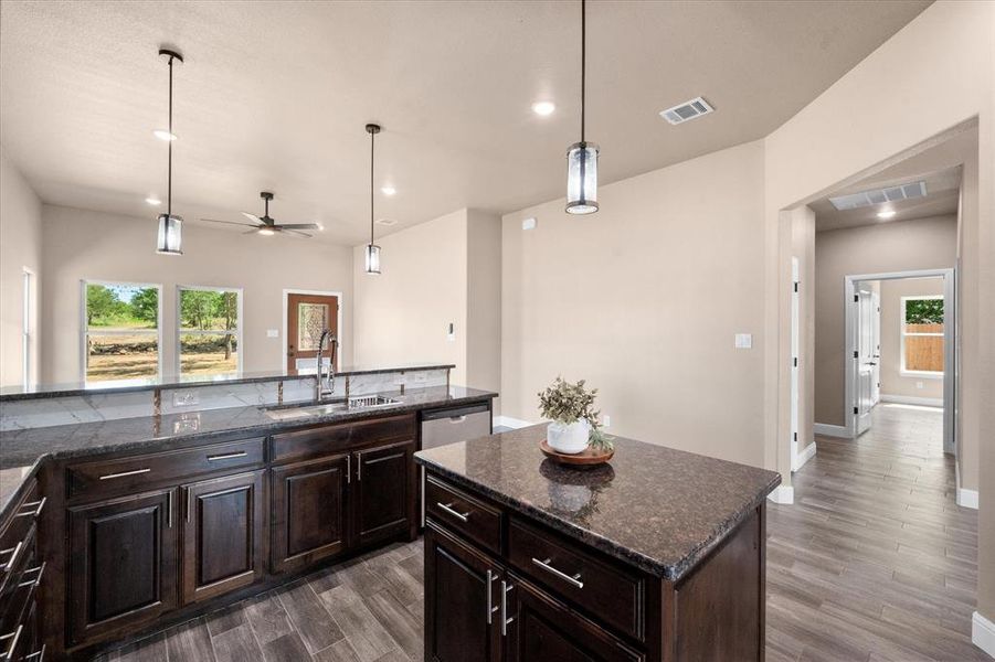 Kitchen featuring knotty alder wood cabinetry, a central island, and granite countertops