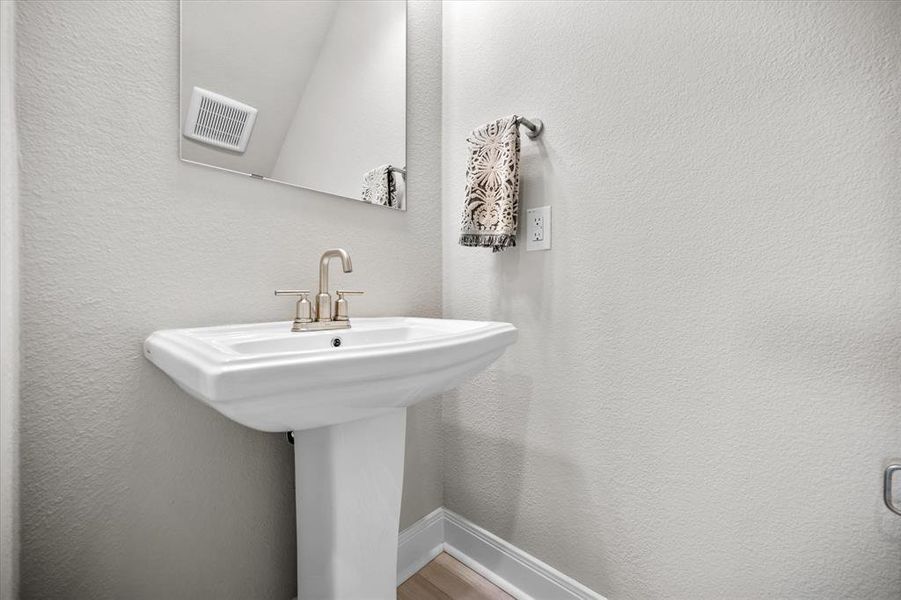 Bathroom with a textured wall and wood finished floors Bathroom with a textured wall and wood finished floors