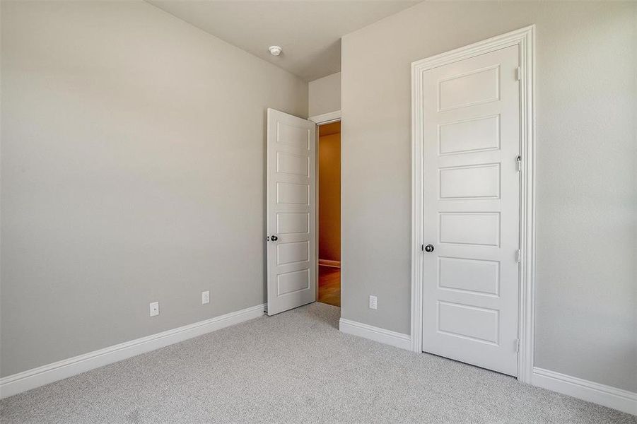 Unfurnished bedroom featuring light colored carpet