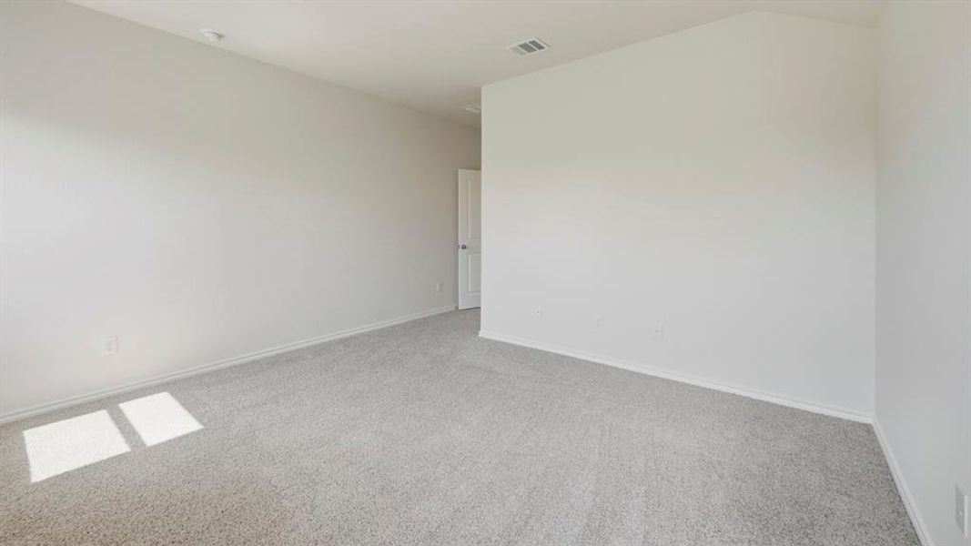 Empty room with light carpet and lofted ceiling