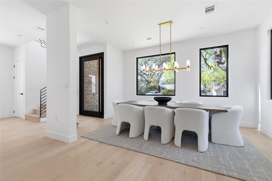 Dining room featuring suspended lighting and light wood-style flooring