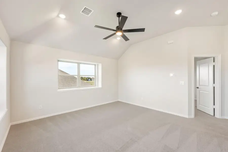 Empty bedroom with vaulted ceiling, ceiling fan, carpet flooring, and a single window