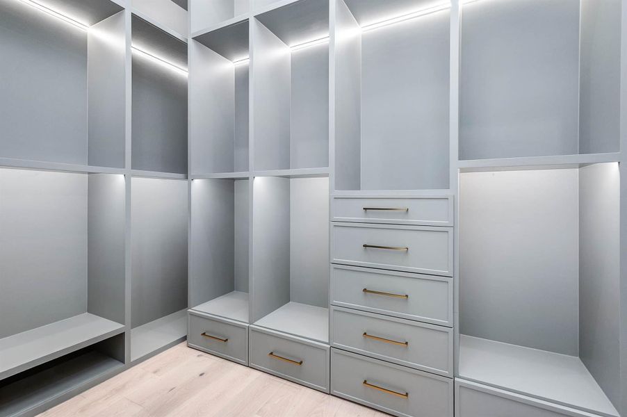 Walk-in closet with custom built-ins and LED-lit shelving, combining style and functionality for an organized, luxurious feel.
