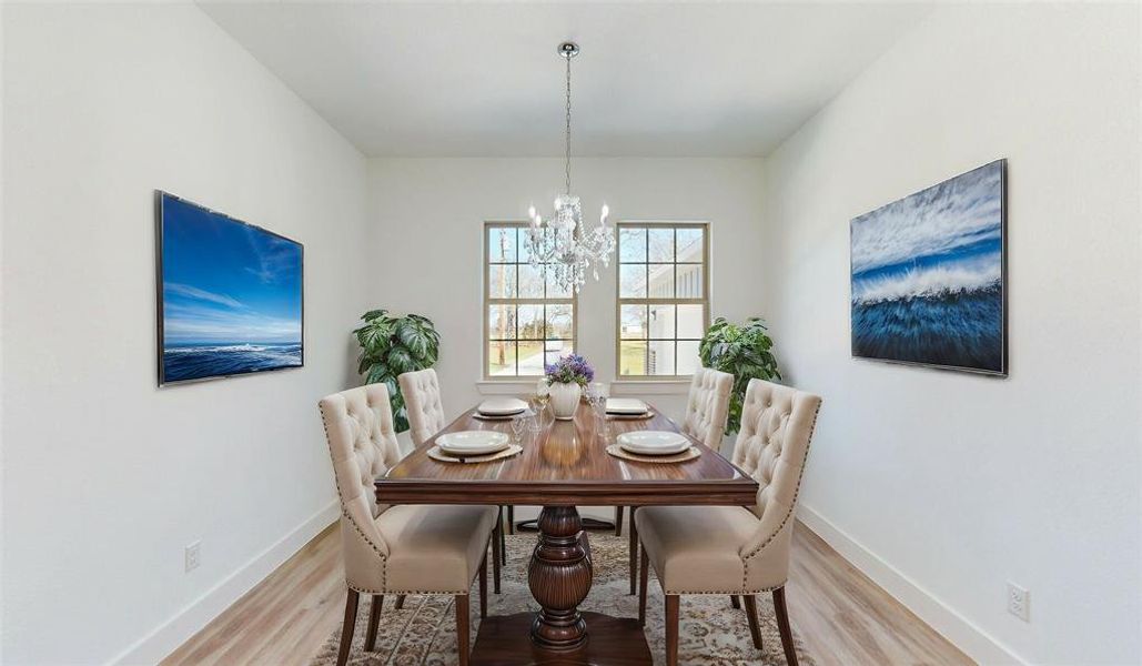 Dining space with a chandelier, light wood-style flooring, and baseboards