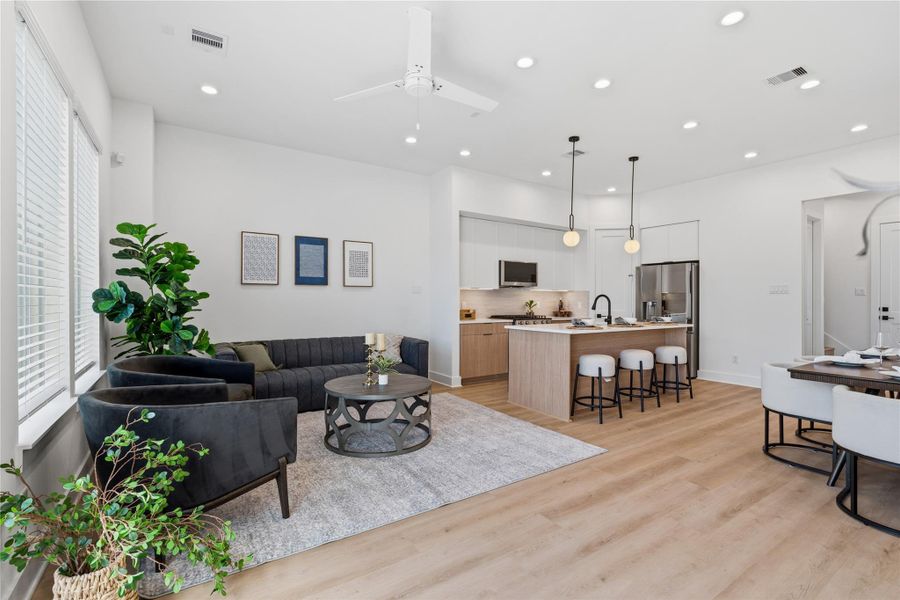 Open-concept living and kitchen area with 10’ ceilings, expansive windows, and seamless flow, ideal for entertaining.