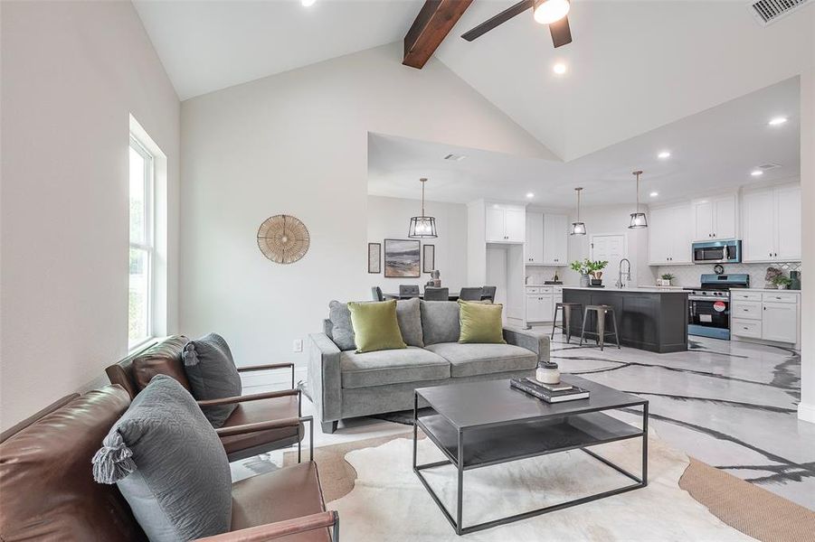 Living room with sink, beam ceiling, ceiling fan, and high vaulted ceiling