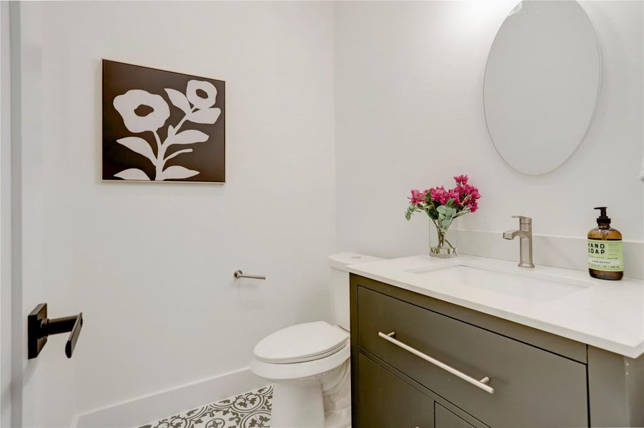 The half bath has custom tile floor, contemporary solid-wood cabinets, and elegant 3cm quartz counters. The half bath has custom tile floor, contemporary solid-wood cabinets, and elegant 3cm quartz counters.