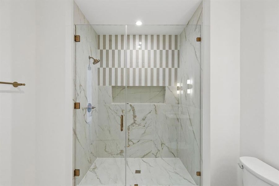 Bathroom featuring a marble finish shower and recessed lighting