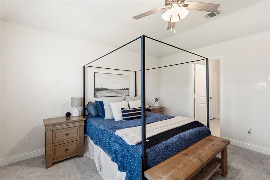 Bright bedroom featuring light-colored walls and grey carpet flooring