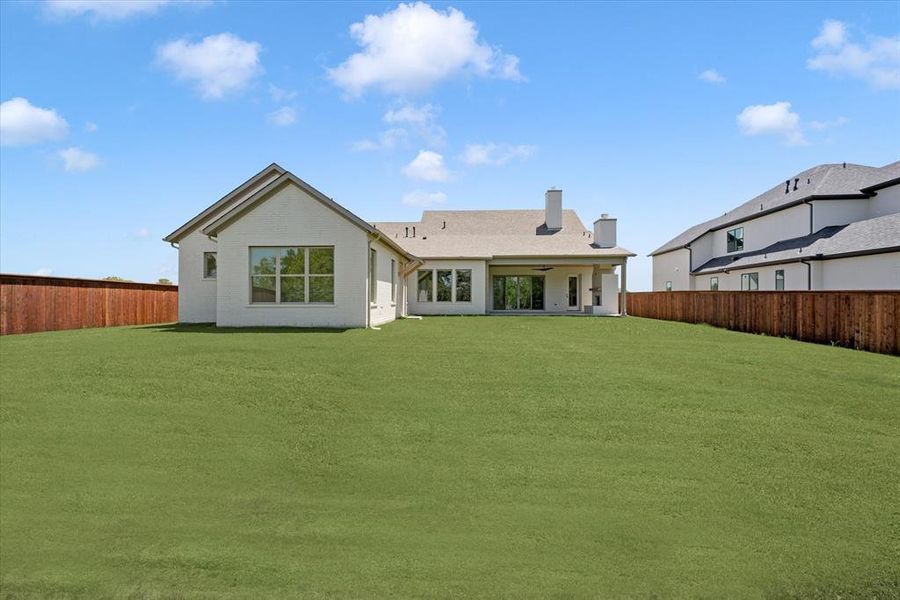 Back of house featuring a yard