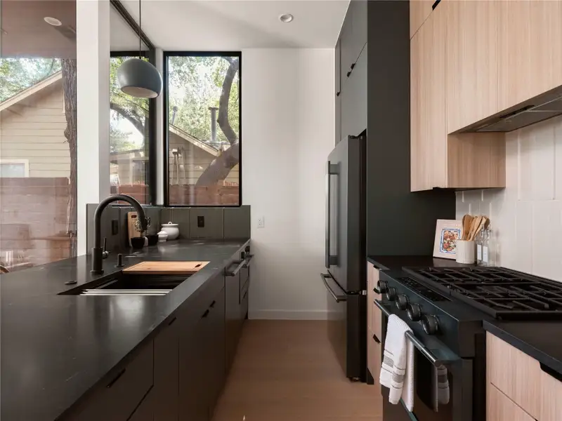 A well-appointed kitchen features a gas range, large sink, and ample counter space, illuminated by natural light. A well-appointed kitchen features a gas range, large sink, and ample counter space, illuminated by natural light.