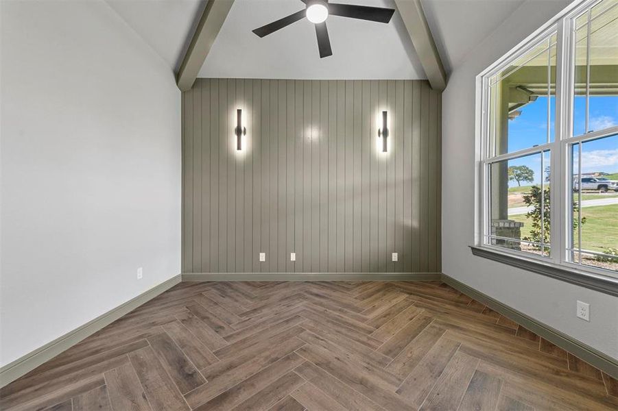 Office  with wood looking tilled flooring, lofted ceiling with beams, ceiling fan, and wooden walls