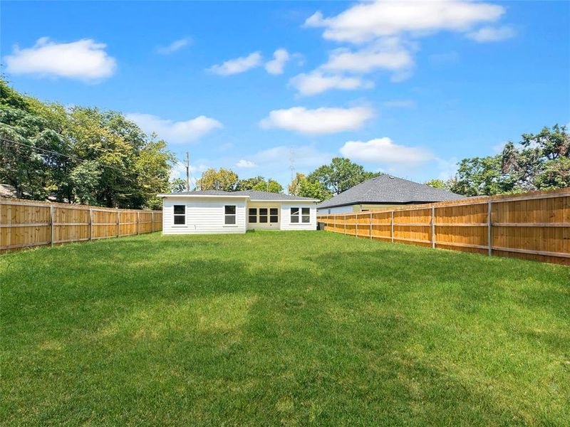 Back of house with a fenced backyard