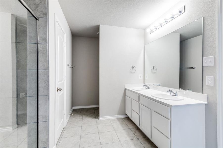 Bathroom with tile patterned floors, vanity, and a textured ceiling