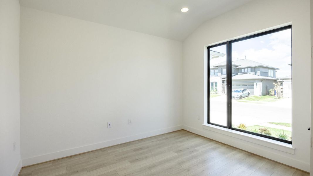 Empty room featuring light wood-style flooring, recessed lighting, and lofted ceiling Empty room featuring light wood-style flooring, recessed lighting, and lofted ceiling
