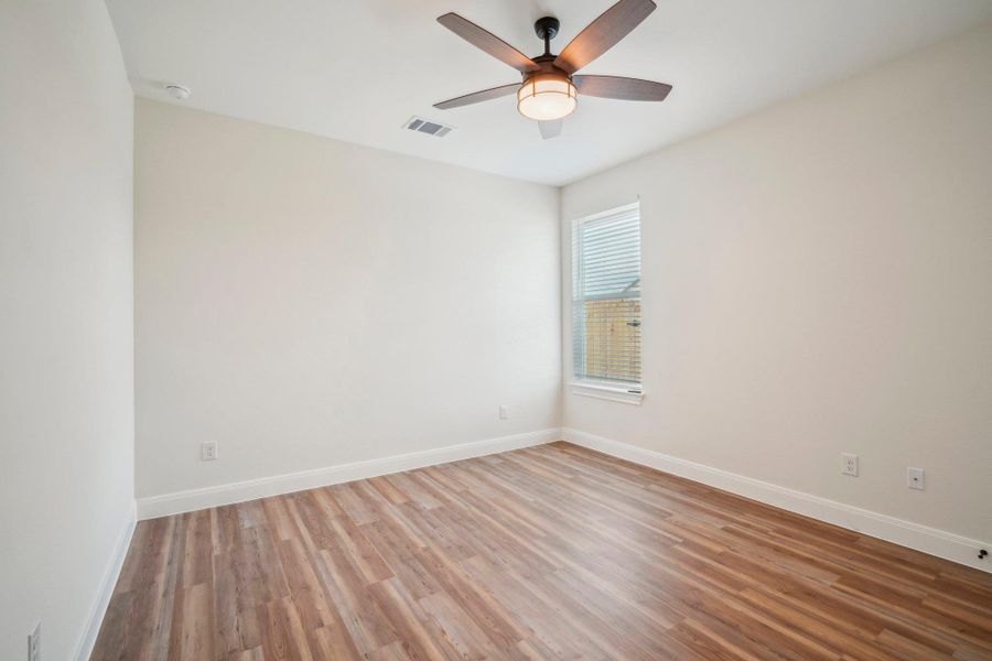 Bedroom 3 with visible vents, ceiling fan, baseboards, and wood finished floors