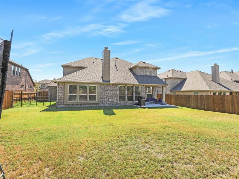 Back of property featuring a patio and a yard