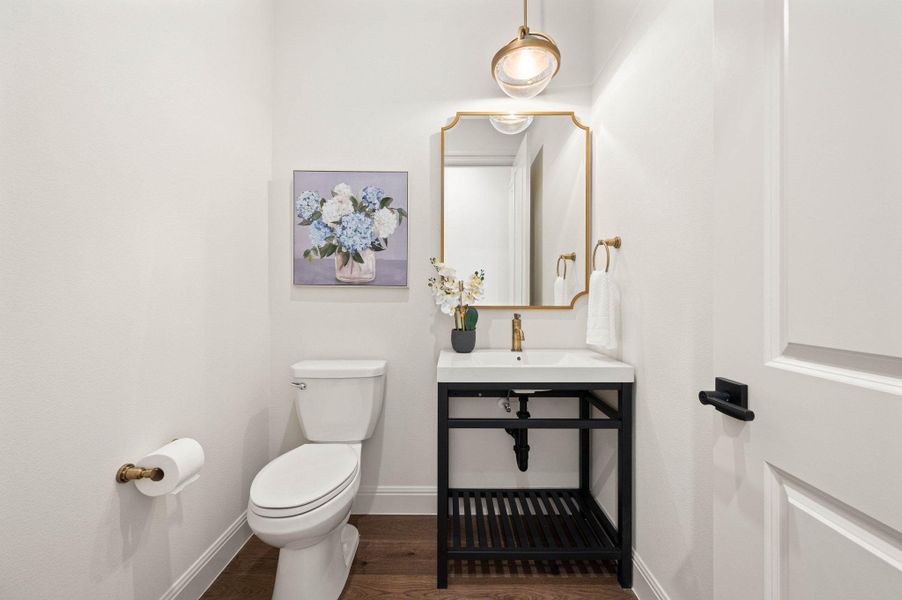 Half bath featuring wood-type flooring and toilet