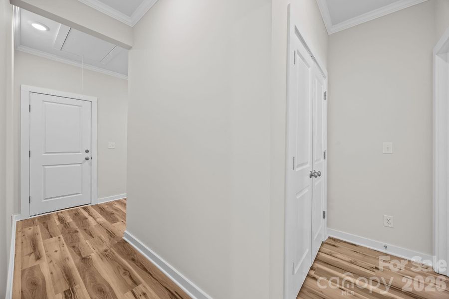 Hallway leading to Primary Bedroom to the right, utility room to the left Hallway leading to Primary Bedroom to the right, utility room to the left