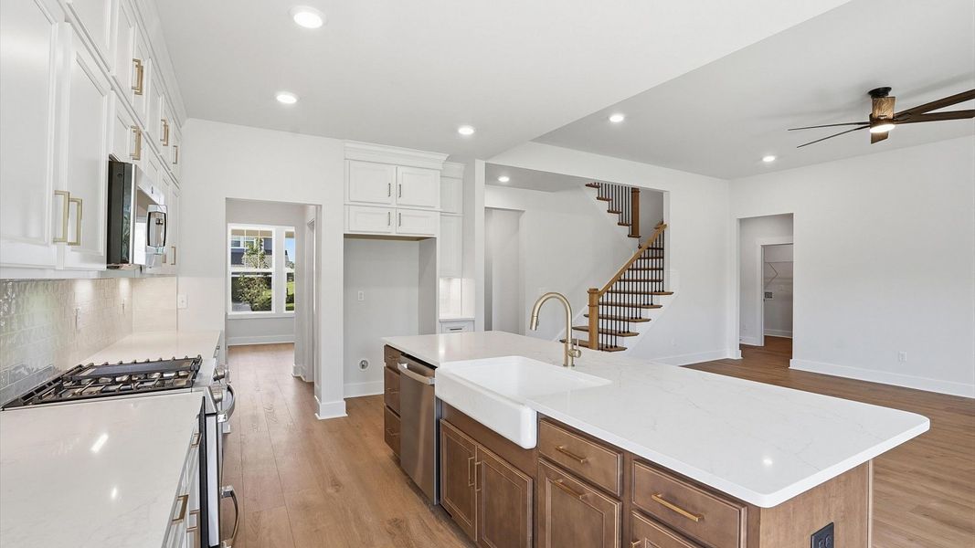 Accomplished design in a kitchen that blends function and form with a right-sized island by DRB Homes Accomplished design in a kitchen that blends function and form with a right-sized island by DRB Homes