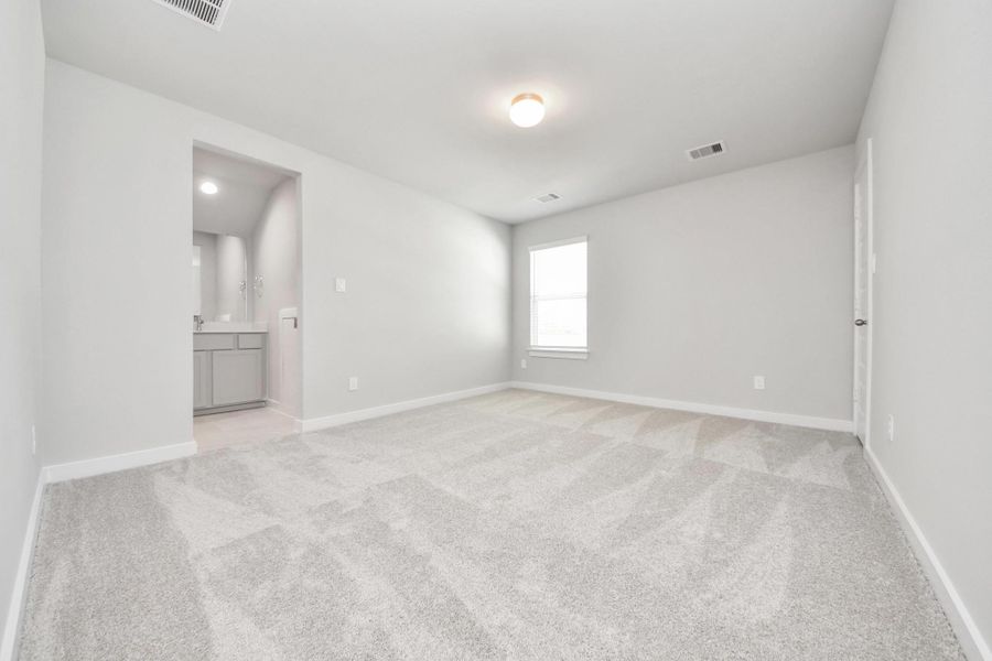 Secondary bedroom features plush carpeting, large windows that let in plenty of natural light, bright paint, and spacious closets. Sample photo of completed home with similar floor plan. Actual colors and selections may vary.