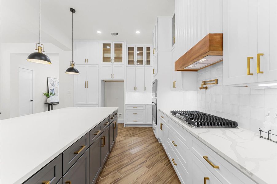 Chef’s dream kitchen featuring custom cabinetry, oversized island, quartz counters, modern fixtures, and abundant windows that overlook the backyard. Chef’s dream kitchen featuring custom cabinetry, oversized island, quartz counters, modern fixtures, and abundant windows that overlook the backyard.