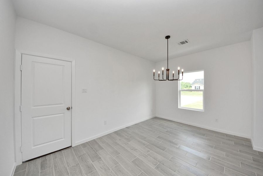 Bright dining area featuring modern light fixture. Bright dining area featuring modern light fixture.