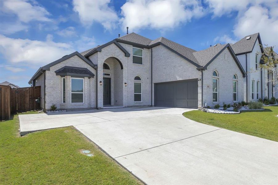 View of front of house featuring a garage and a front lawn