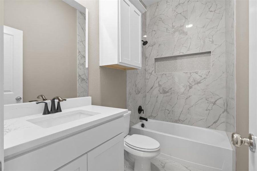 Full bathroom with tiled shower / bath, vanity, and toilet