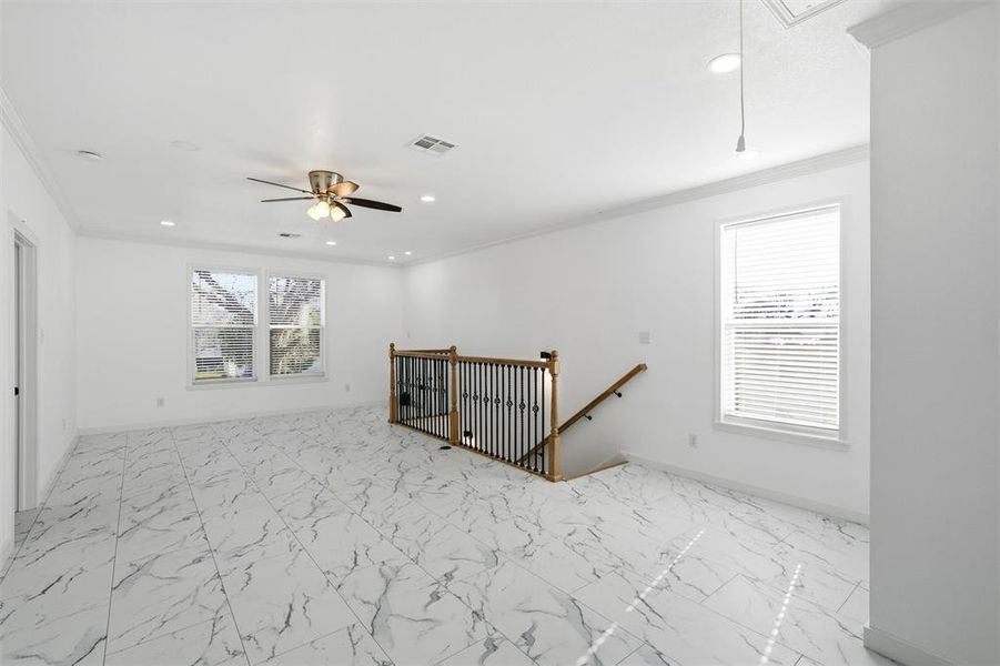 Empty room featuring attic access, light marble finish flooring, ornamental molding, and recessed lighting Empty room featuring attic access, light marble finish flooring, ornamental molding, and recessed lighting