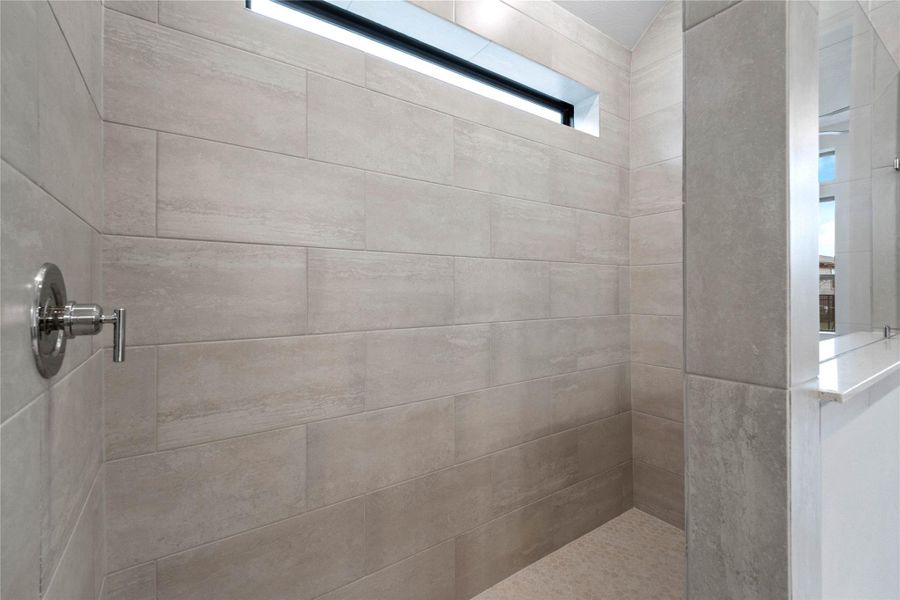 This spa-inspired primary bathroom is designed with modern, clean lines and elegant finishes. The generously sized walk-in shower caters to all needs, offering ample room for a quick morning shower or a long, indulgent, spa-worthy escape at the end of the day.