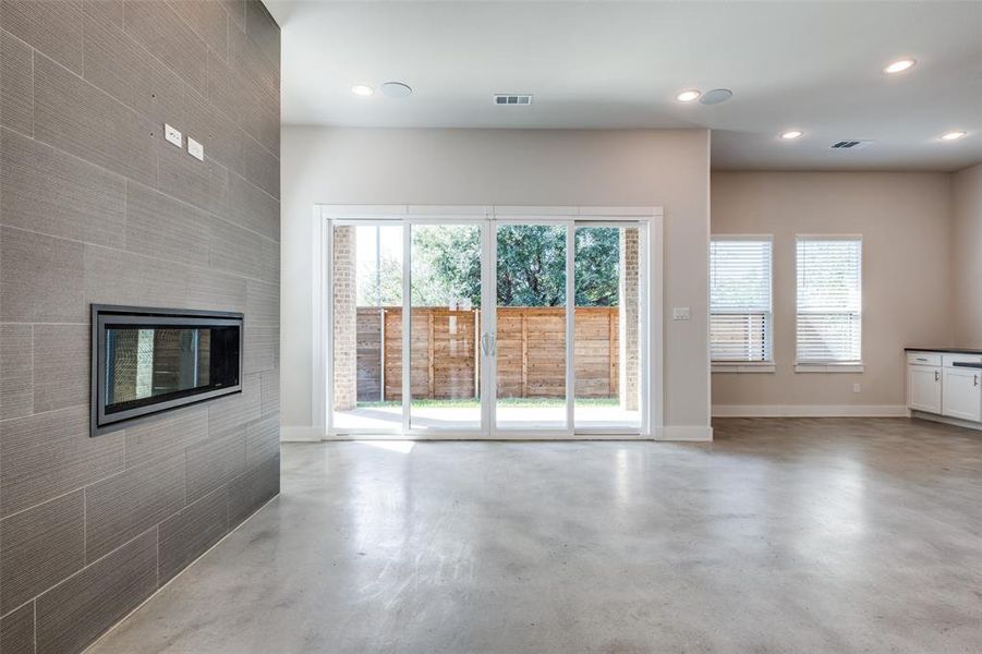 Living room featuring concrete flooring and a tile fireplace