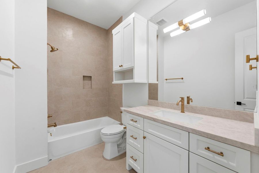 Bathroom #5 (Attached to Bedroom #4) Featuring a shower/ tub combo, WHITE cabinets, gold hardware, MODERN light fixture, and SPA- like inspired tile.