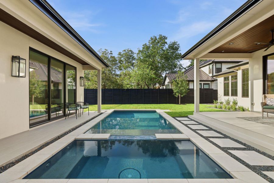 View of pool with a patio area, a fenced backyard, a ceiling fan, and a pool with connected hot tub