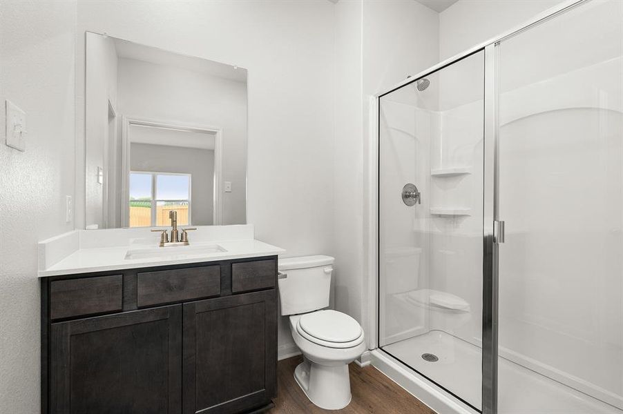 Full bathroom featuring a shower stall, wood finished floors, and vanity Full bathroom featuring a shower stall, wood finished floors, and vanity