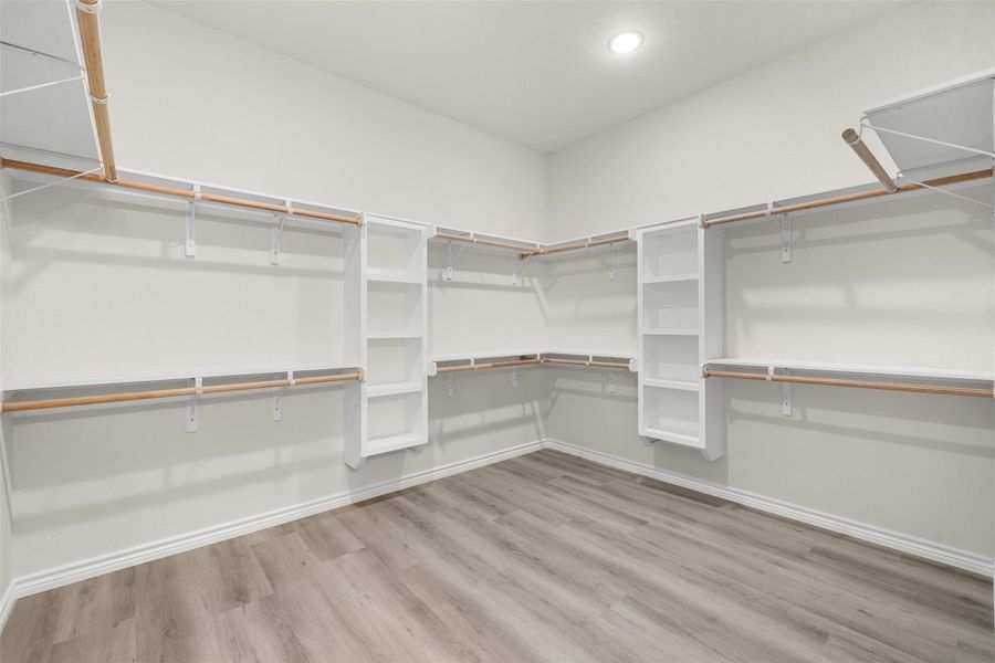 Walk-in closet with ample shelving and hanging rods to organize your wardrobe. Walk-in closet with ample shelving and hanging rods to organize your wardrobe.