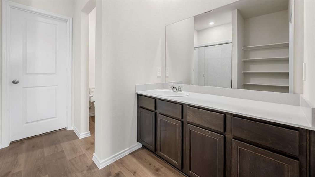 Bathroom featuring vanity, dark wood-type flooring, a shower, and recessed lighting
