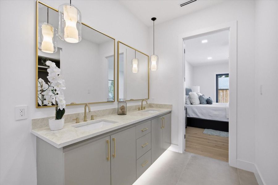 Dual vanities with refined finishes and warm brass accents create a polished, elevated daily experience.